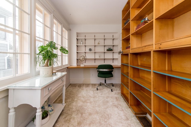 carpeted office space featuring built in study area