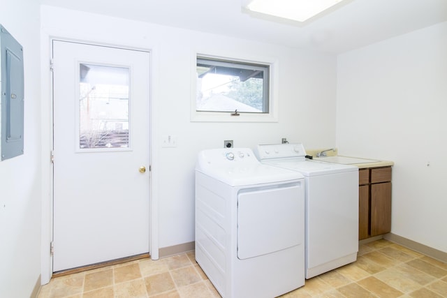 clothes washing area featuring independent washer and dryer, cabinet space, a wealth of natural light, and electric panel