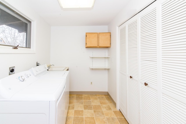 clothes washing area featuring washing machine and dryer, laundry area, and baseboards