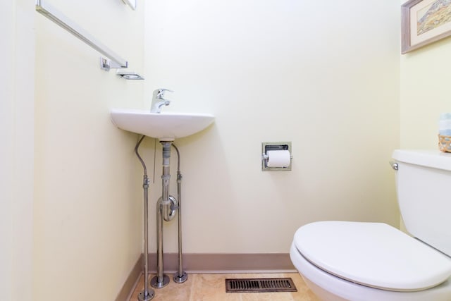 bathroom featuring toilet, tile patterned flooring, visible vents, and baseboards