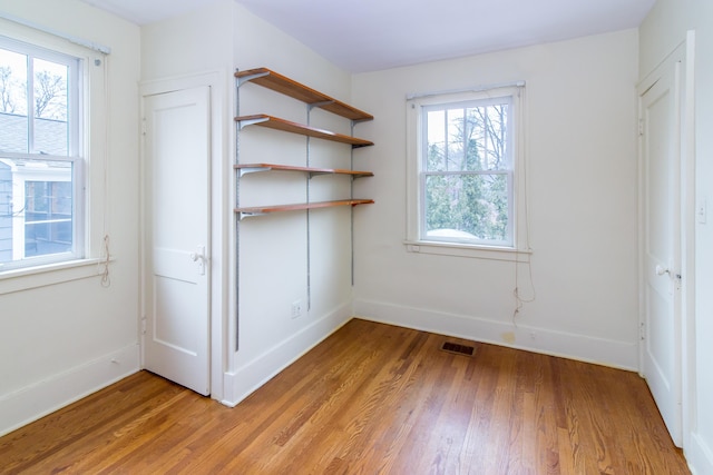 unfurnished bedroom featuring a closet, visible vents, light wood-style flooring, and baseboards