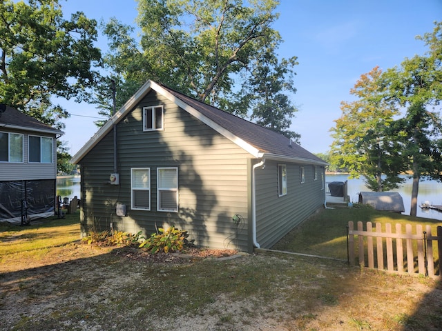 view of side of home with a lawn and fence