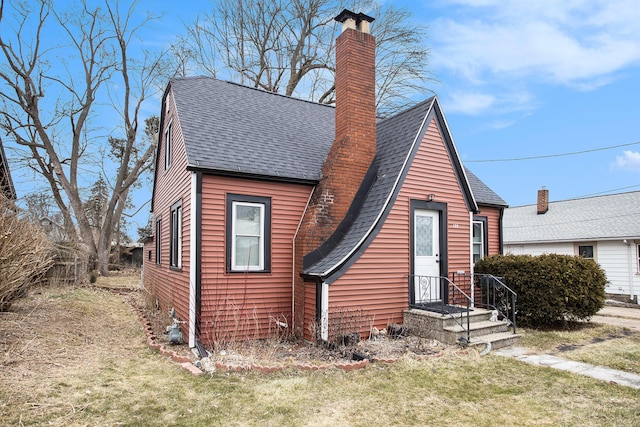 view of front of house with a shingled roof, a front yard, fence, and a chimney