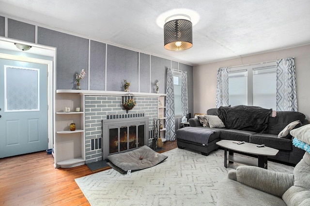 living area featuring hardwood / wood-style floors, a fireplace, and crown molding