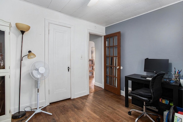 office space with wood-type flooring, arched walkways, and baseboards