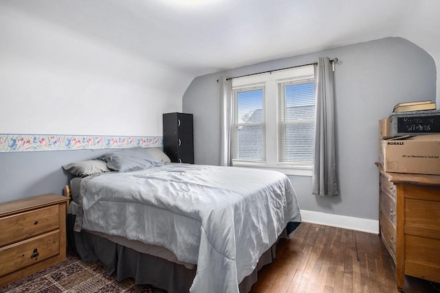 bedroom featuring hardwood / wood-style flooring, baseboards, and vaulted ceiling