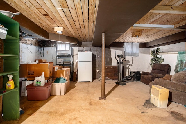 below grade area with wooden ceiling and freestanding refrigerator