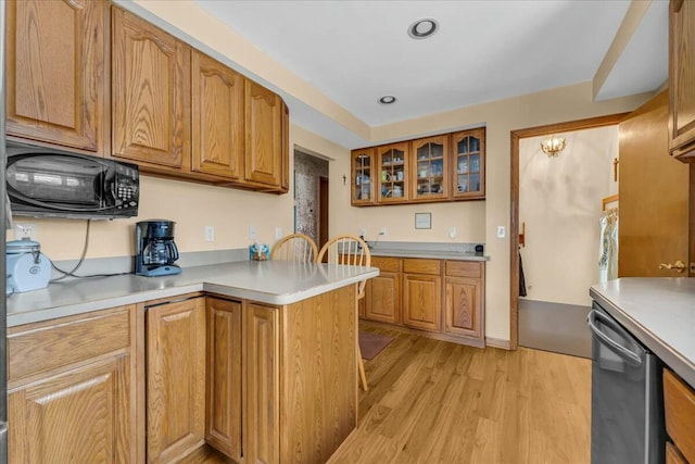 kitchen featuring light wood-type flooring, brown cabinets, and stainless steel dishwasher