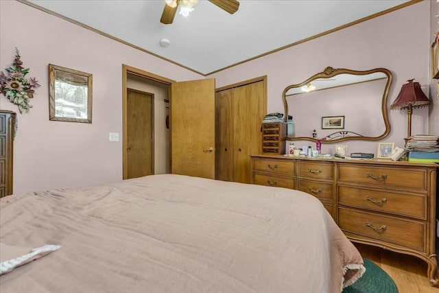 bedroom with a closet, a ceiling fan, wood finished floors, and ornamental molding