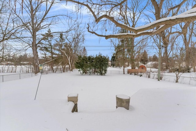 yard layered in snow featuring a fenced backyard