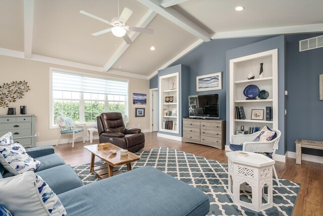 living area featuring visible vents, vaulted ceiling with beams, baseboards, and wood finished floors