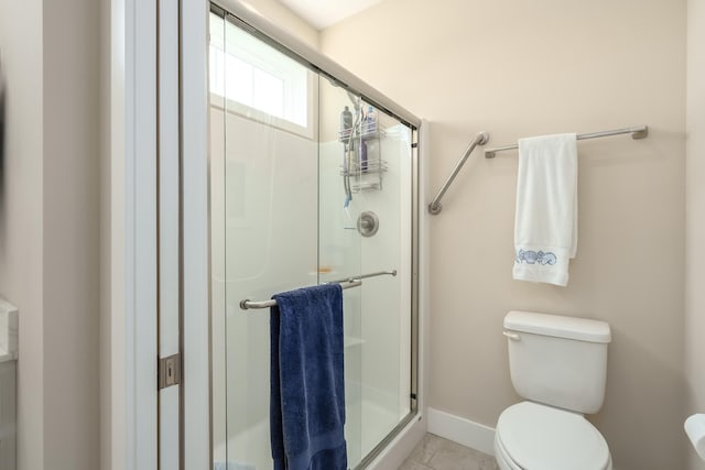 full bath with a stall shower, baseboards, toilet, and tile patterned floors