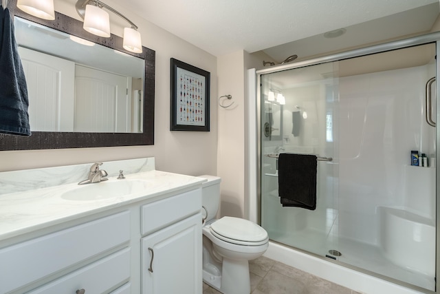 bathroom featuring a stall shower, tile patterned flooring, vanity, and toilet