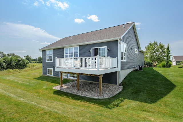 back of property featuring roof with shingles, a yard, and a wooden deck