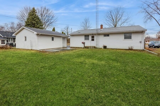 back of house with a yard, a patio, and an outdoor structure