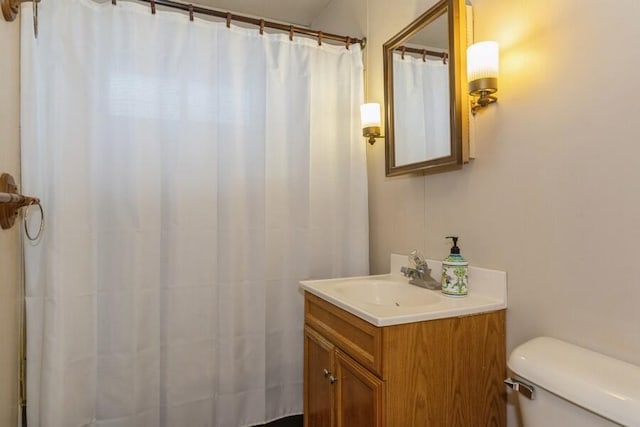 bathroom with toilet, curtained shower, and vanity