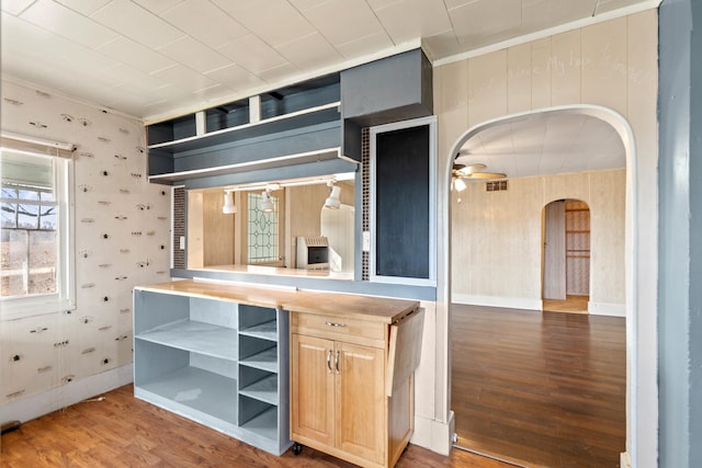 kitchen with arched walkways, ceiling fan, light brown cabinets, wood finished floors, and open shelves