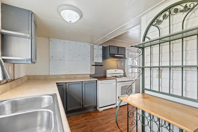 kitchen featuring white appliances, under cabinet range hood, gray cabinets, and wood finished floors