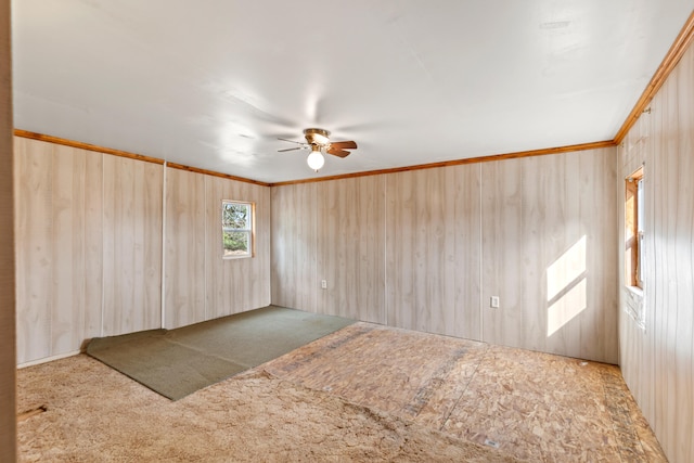 empty room featuring carpet floors, ornamental molding, and a ceiling fan