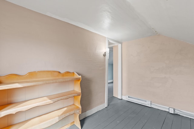 staircase with a baseboard heating unit, wood-type flooring, lofted ceiling, and baseboards