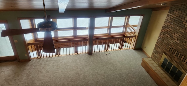 interior space with carpet floors, beam ceiling, and a wealth of natural light