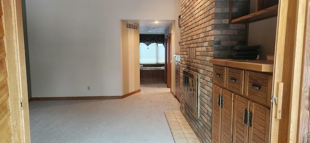 hall with light colored carpet, visible vents, and baseboards