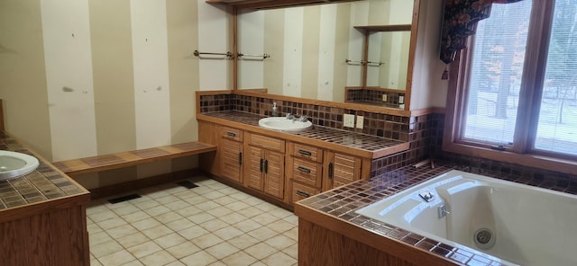 full bath with tile patterned floors, tasteful backsplash, a tub with jets, and vanity