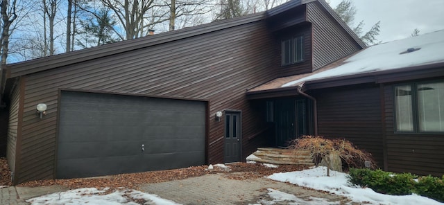 view of snowy exterior with a garage