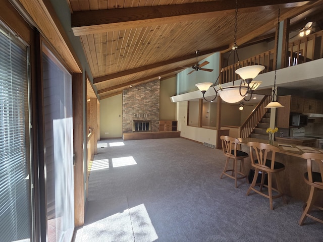3075 Mineral Springs Trl, Mount Pleasant, MI 48858 - unfurnished dining area featuring a wood ceiling with exposed beams, carpet, ceiling fan, a brick fireplace, and high vaulted ceiling