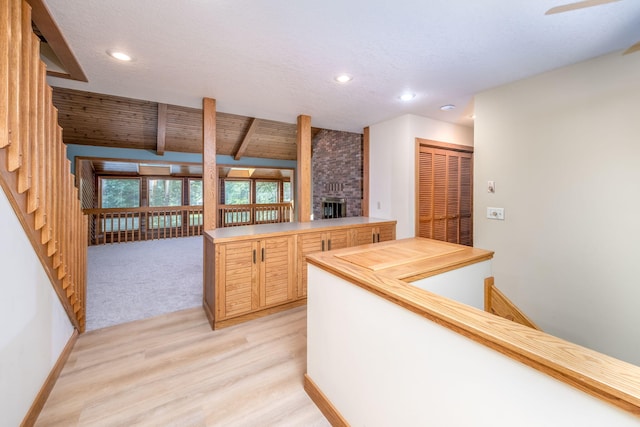 3075 Mineral Springs Trl, Mount Pleasant, MI 48858 - kitchen featuring a fireplace, light wood-type flooring, recessed lighting, light brown cabinetry, and a peninsula