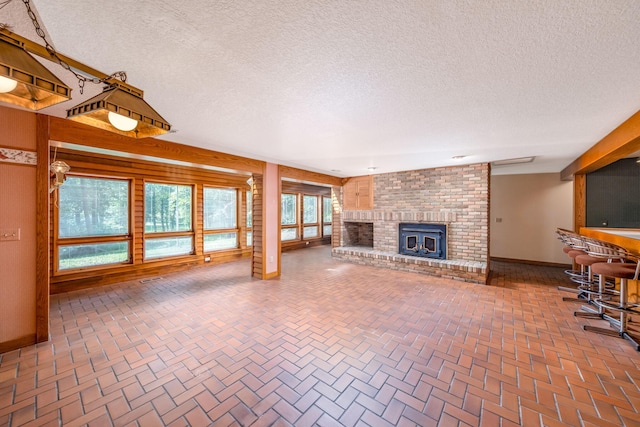 3075 Mineral Springs Trl, Mount Pleasant, MI 48858 - unfurnished living room with a textured ceiling and a fireplace