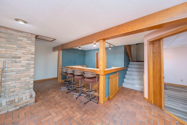 3075 Mineral Springs Trl, Mount Pleasant, MI 48858 - indoor dry bar with stairway, brick flooring, and rail lighting