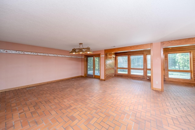 3075 Mineral Springs Trl, Mount Pleasant, MI 48858 - spare room featuring brick patterned flooring and a chandelier