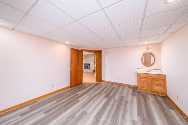 3075 Mineral Springs Trl, Mount Pleasant, MI 48858 - below grade area with a paneled ceiling, light wood-style flooring, a large fireplace, and recessed lighting