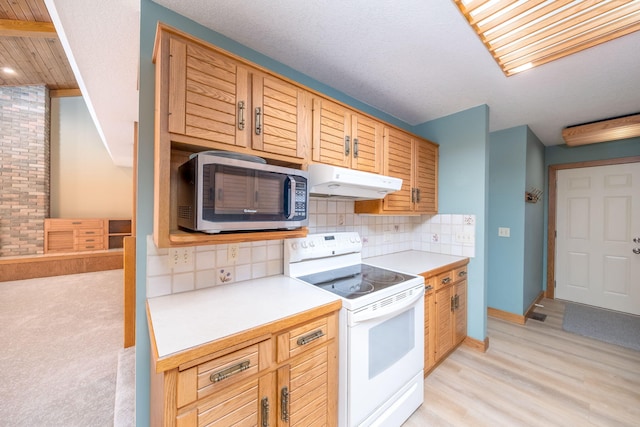 3075 Mineral Springs Trl, Mount Pleasant, MI 48858 - kitchen with stainless steel microwave, white range with electric cooktop, under cabinet range hood, backsplash, and light countertops
