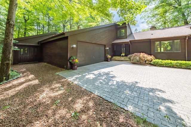 3075 Mineral Springs Trl, Mount Pleasant, MI 48858 - mid-century home with decorative driveway, a garage, and a chimney