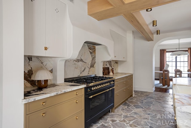 727 Plymouth Rd SE, East Grand Rapids, MI 49506 - kitchen featuring double oven range, arched walkways, beamed ceiling, backsplash, and stone flooring