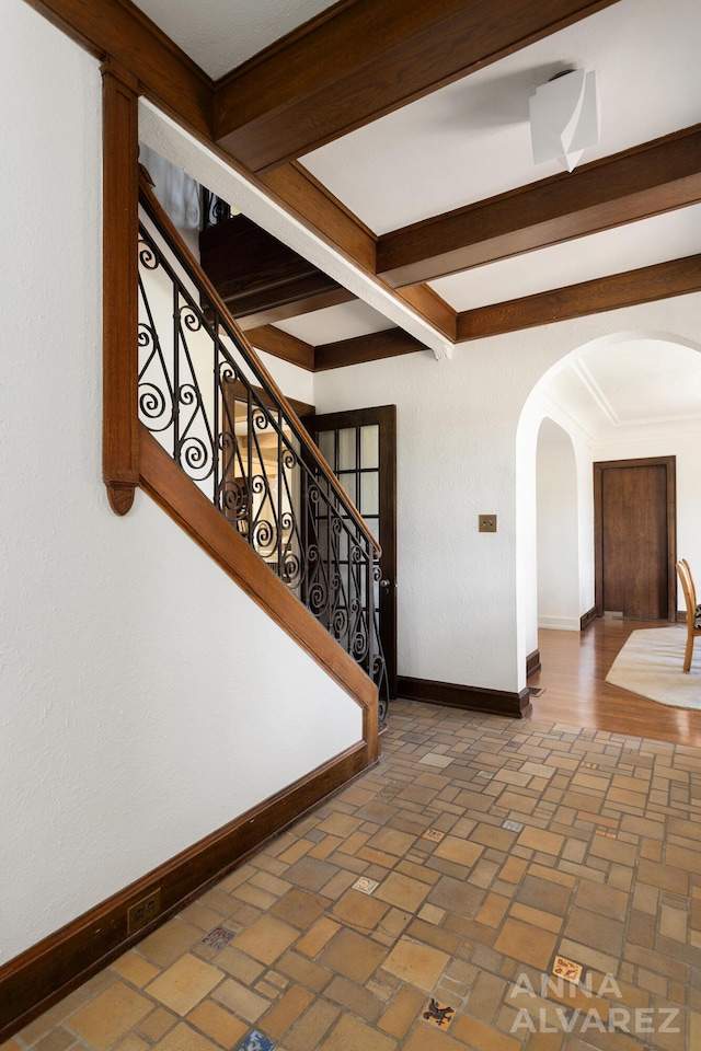 727 Plymouth Rd SE, East Grand Rapids, MI 49506 - hallway with arched walkways, beamed ceiling, brick patterned floors, and stairway