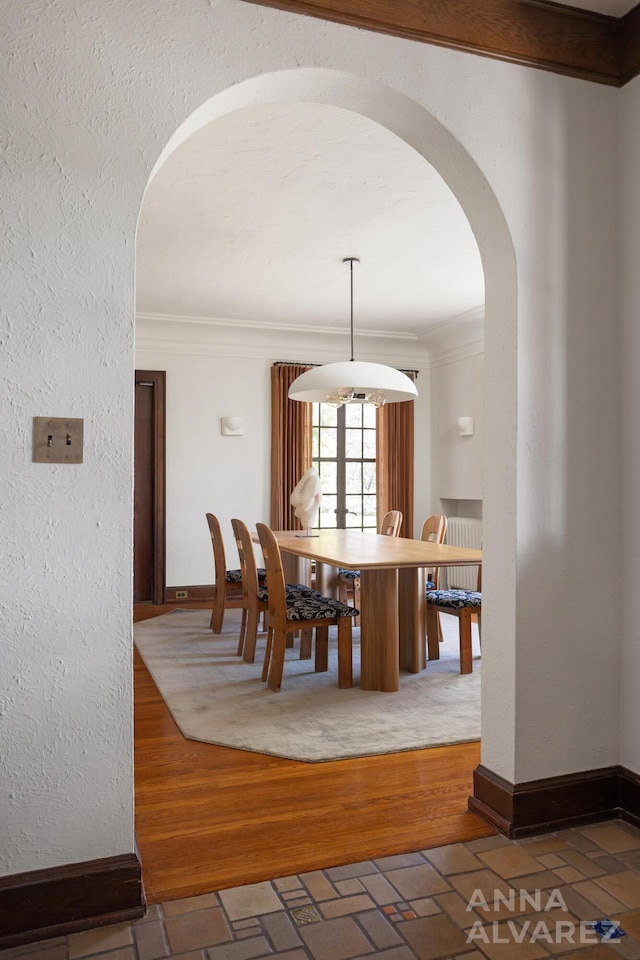 727 Plymouth Rd SE, East Grand Rapids, MI 49506 - dining area with arched walkways, ornamental molding, brick patterned flooring, and a textured wall