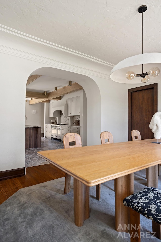 727 Plymouth Rd SE, East Grand Rapids, MI 49506 - dining area featuring arched walkways, wood finished floors, and ornamental molding