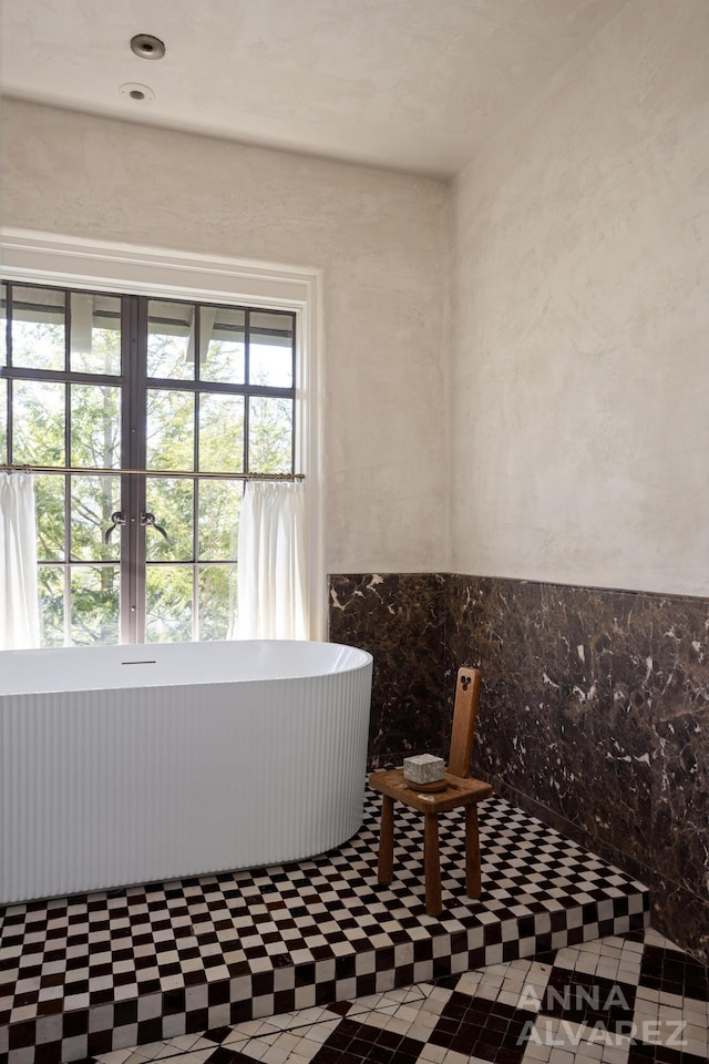 727 Plymouth Rd SE, East Grand Rapids, MI 49506 - bathroom with healthy amount of natural light, a freestanding tub, and tile patterned floors
