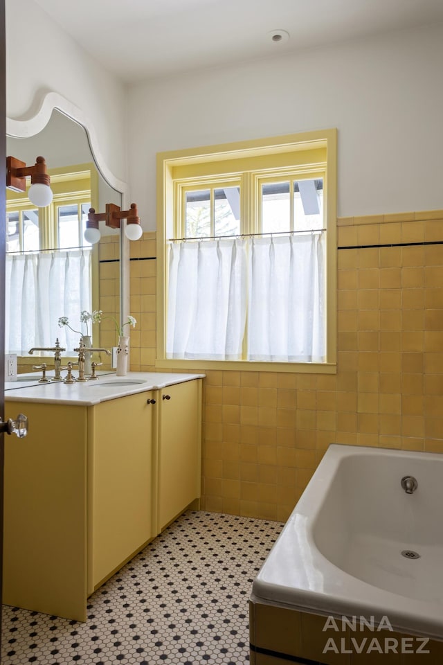 727 Plymouth Rd SE, East Grand Rapids, MI 49506 - full bathroom featuring plenty of natural light, tile walls, vanity, a garden tub, and a wainscoted wall
