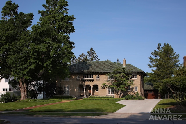 727 Plymouth Rd SE, East Grand Rapids, MI 49506 - view of front of home featuring driveway, a front yard, a chimney, and a garage