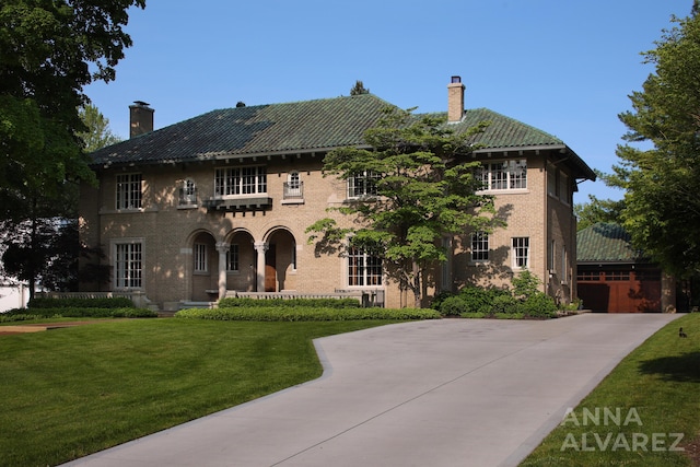 727 Plymouth Rd SE, East Grand Rapids, MI 49506 - colonial inspired home featuring a chimney, a front lawn, brick siding, and a detached garage