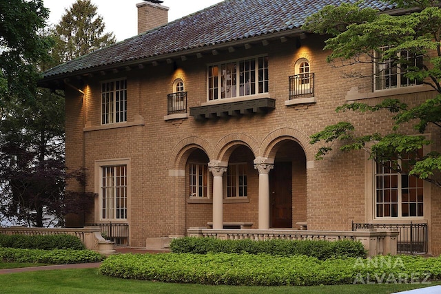 727 Plymouth Rd SE, East Grand Rapids, MI 49506 - view of front of house featuring a balcony, brick siding, and a chimney