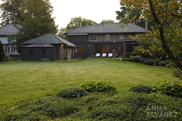 727 Plymouth Rd SE, East Grand Rapids, MI 49506 - rear view of house with a chimney, a yard, and a tile roof