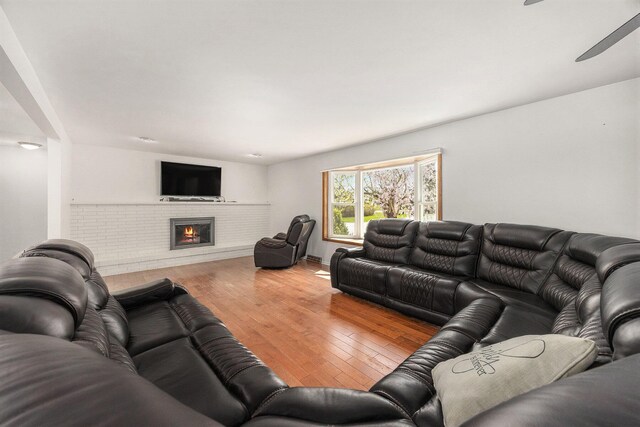 6665 E Lake St, Sand Lake, MI 49343 - living area with a fireplace, baseboards, a ceiling fan, and wood finished floors