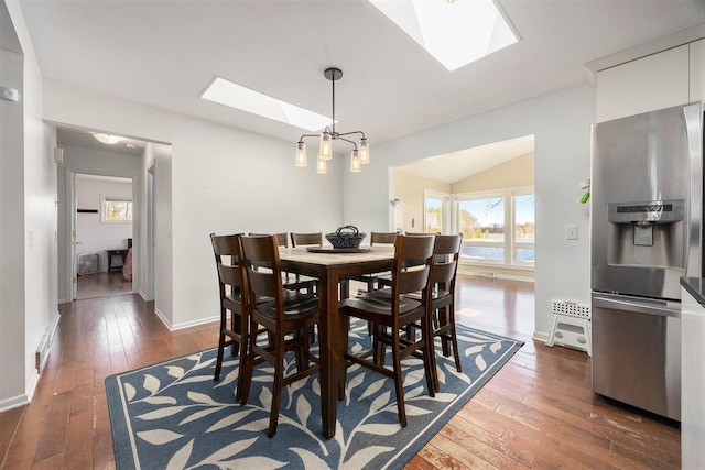 6665 E Lake St, Sand Lake, MI 49343 - dining space with dark wood-type flooring, baseboards, and vaulted ceiling with skylight