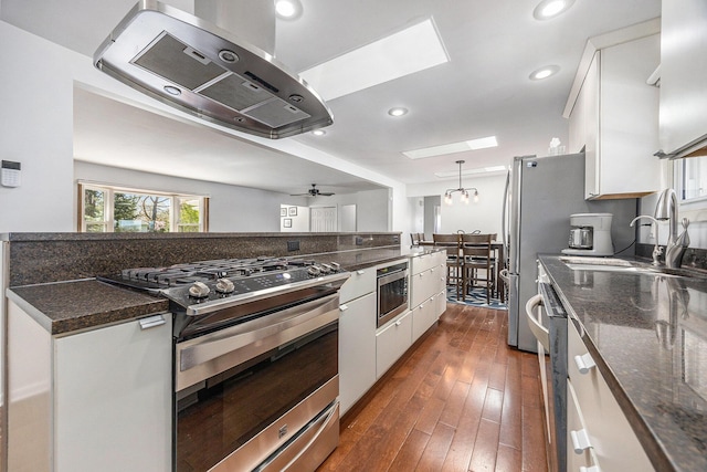 6665 E Lake St, Sand Lake, MI 49343 - kitchen with a sink, a skylight, stainless steel appliances, range hood, and white cabinets