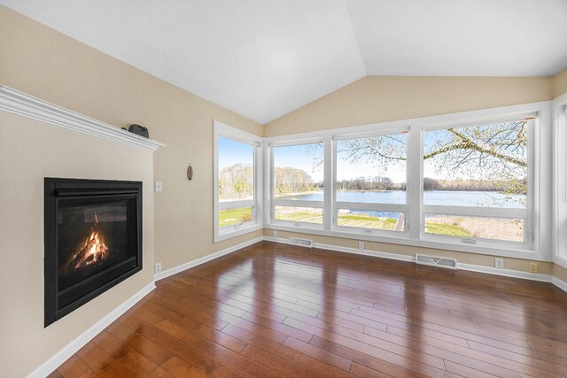6665 E Lake St, Sand Lake, MI 49343 - unfurnished living room with lofted ceiling, visible vents, and plenty of natural light
